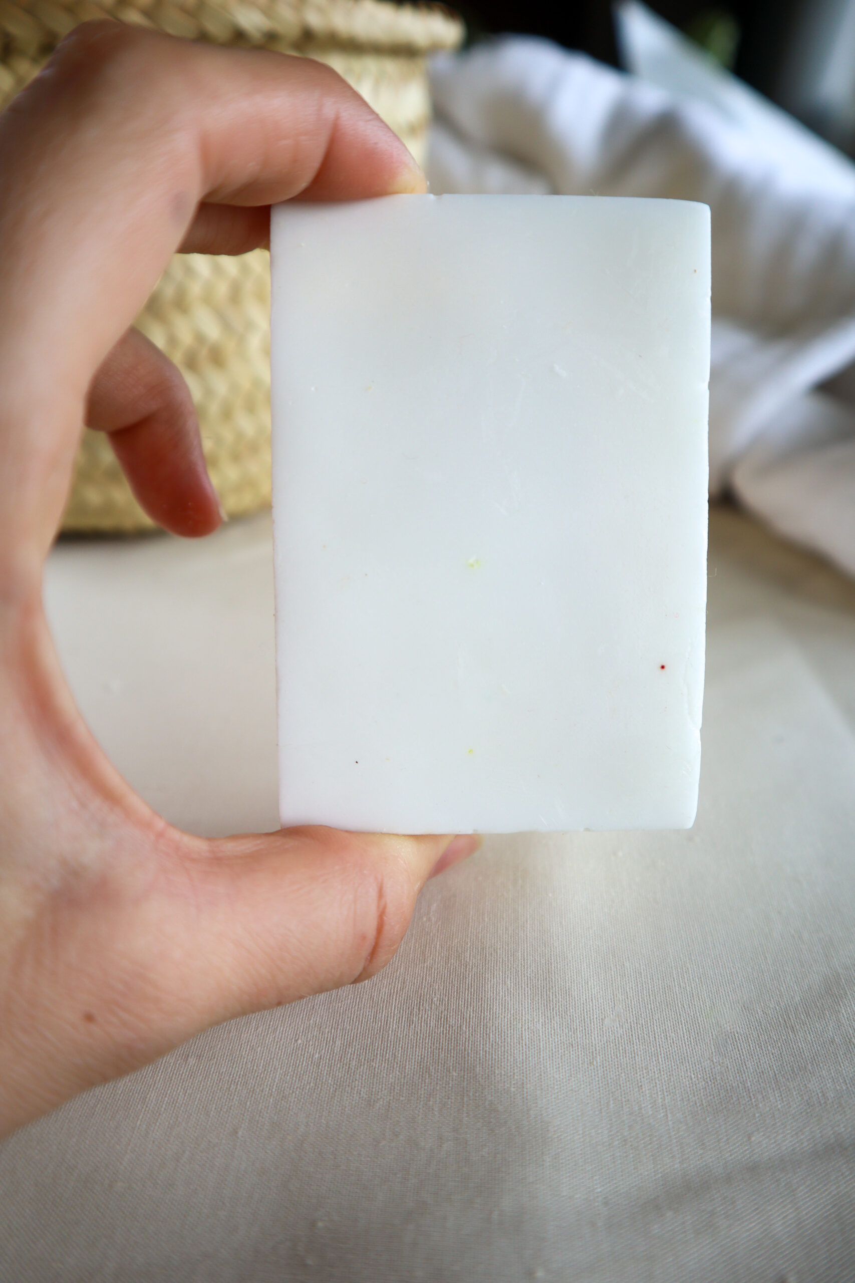 hand holding white soap block in a bathroom
